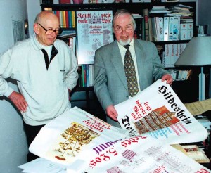 Manfred Oppermann im Jahre 2000 mit dem Typographen Walter Plata (links) vor einer Auswahl Hildesheimer Plakate aus dem Archiv seiner Druckerei. Bild: © hmh.